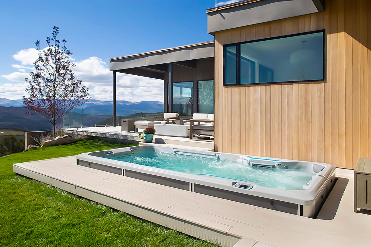inground swim spa set into a pour concrete patio outside of a modern house with covered veranda