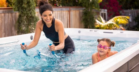 A mom and daughter spending quality time together in an outdoor swim spa