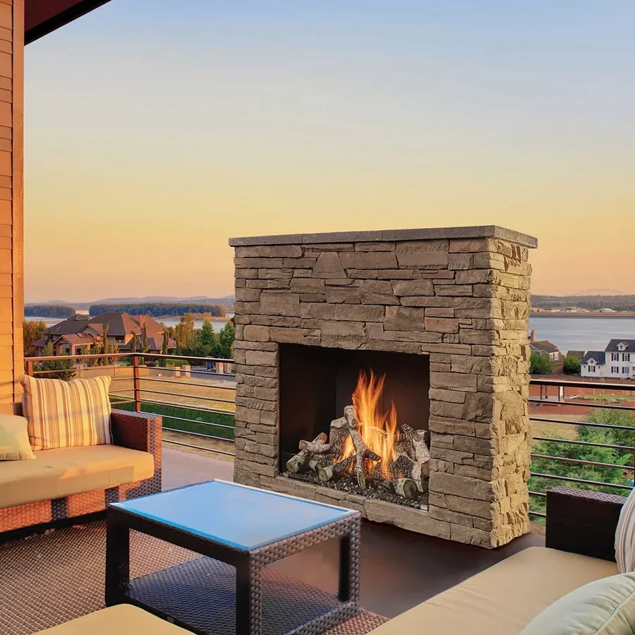 A traditional gas fireplace on an outdoor patio at sunset