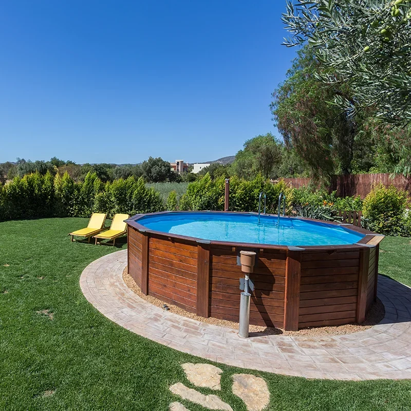 A round above-ground pool in a large backyard with a green lawn