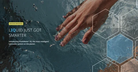 A hand reaching into clean and clear hot tub water with text overlay that reads, "LIQUID JUST GOT SMARTER Introducing FreshWater IQ, the most intelligent salt water system on the planet."