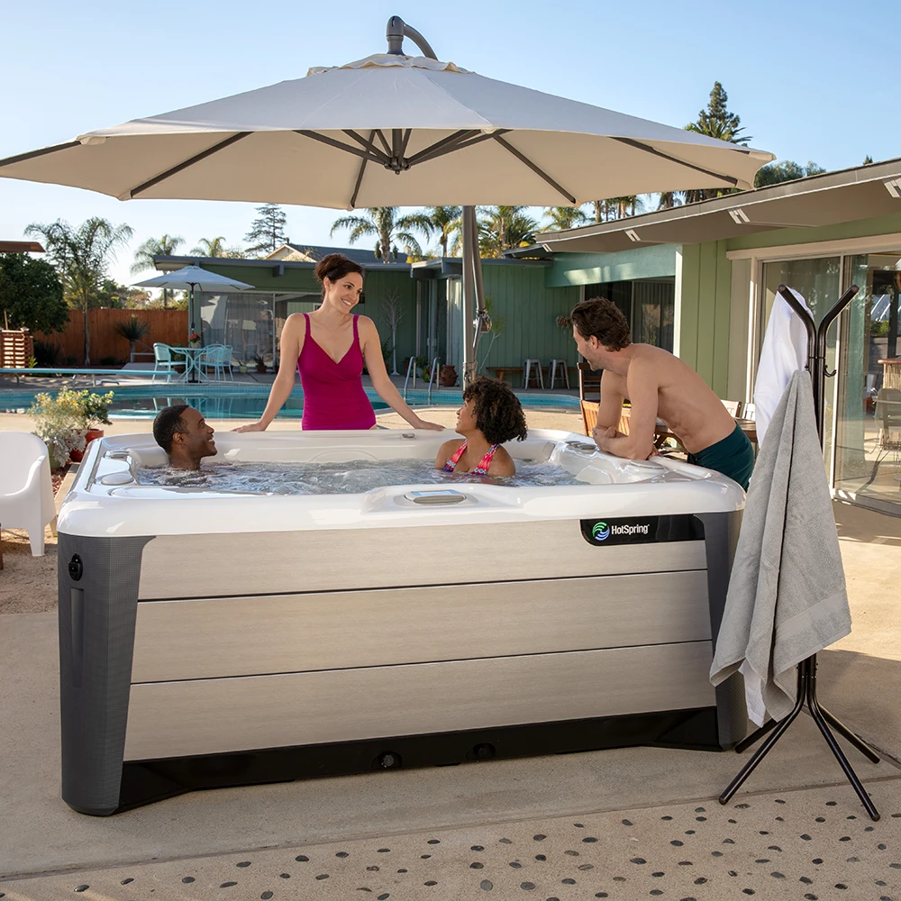 Four adults enjoying a Hot Spring Highlife Vanguard hot tub